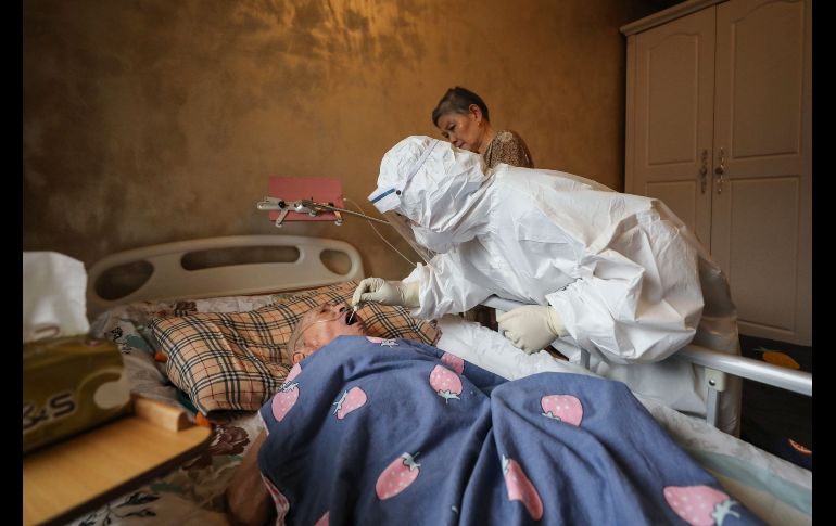 Trabajadores acuden a las viviendas de quienes no pueden salir, como este residente enfermo. AFP