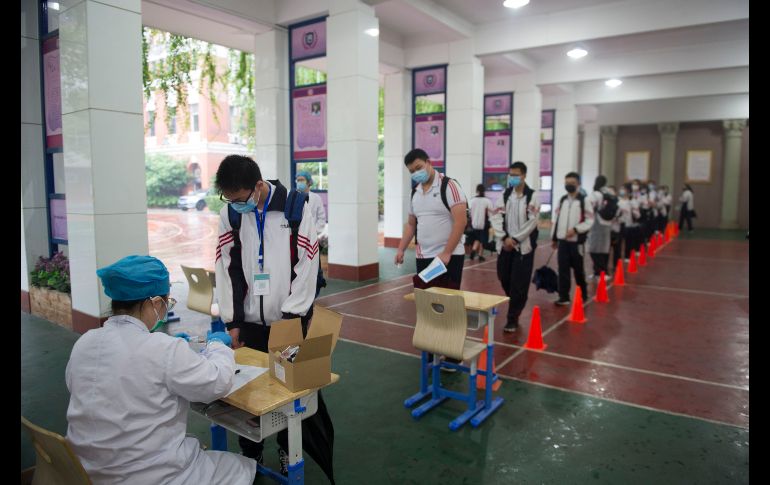 Estudiantes hacen fila para que les tomen muestras. AFP