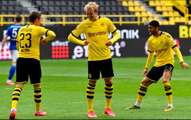 El balón volvió a rodar en los estadios alemanes, aunque sin público en la grada, por lo que los aficionados amarillos tuvieron que festejar a distancia. AFP / M. Meissner