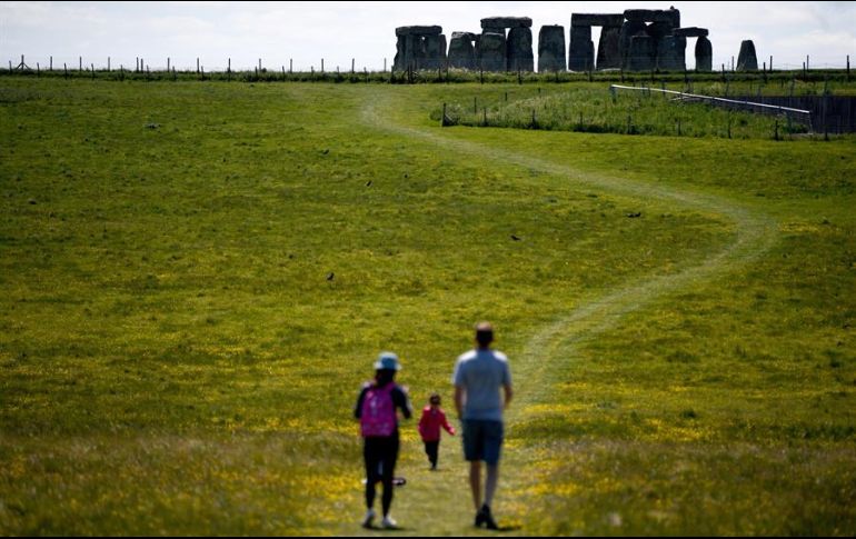 Una familia camina alrededor de las ruinas de Stonehenge. Hace unos días, el Reino Unido alivió algunas restricciones para la población. EFE/N. Hall
