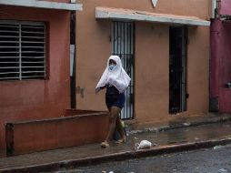 Una mujer se protege de la lluvia este jueves en Santo Domingo. EFE/O. Barría