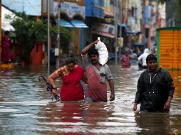 Varias personas cruzan una calle inundada en Pondicherry. EFE