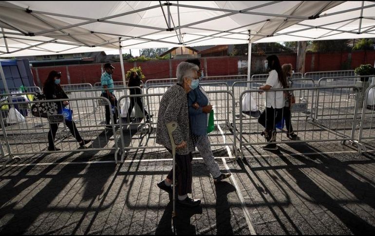 Un grupo de personas se prepara para entrar a un centro de vacunación masivo localizado en la comuna de La Florida, en Santiago. EFE/A. Valdés