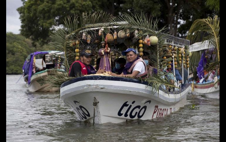 Decenas de personas ataviadas con tradicionales vestimentas católicas llenan de color las aguas del lago en esta solemnidad religiosa. EFE/J. Torres