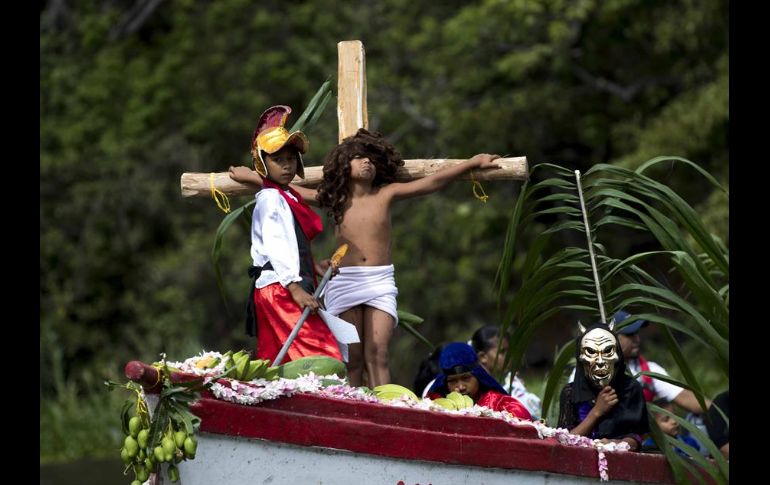 Decenas de personas ataviadas con tradicionales vestimentas católicas llenan de color las aguas del lago en esta solemnidad religiosa. EFE/J. Torres