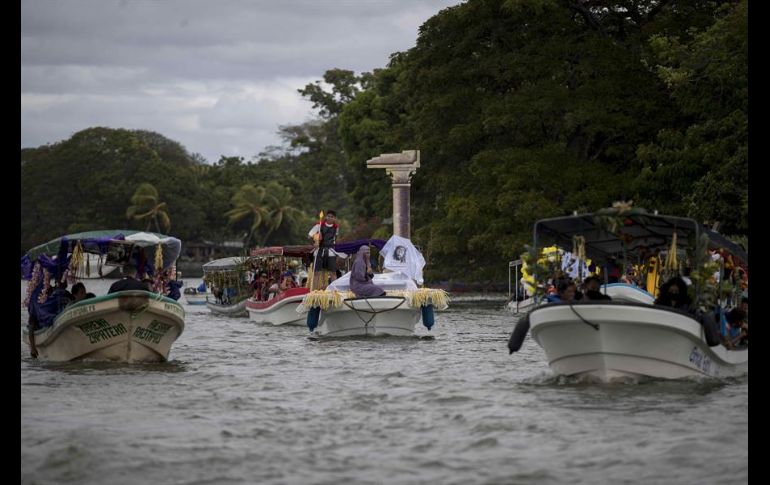 Decenas de personas ataviadas con tradicionales vestimentas católicas llenan de color las aguas del lago en esta solemnidad religiosa. EFE/J. Torres