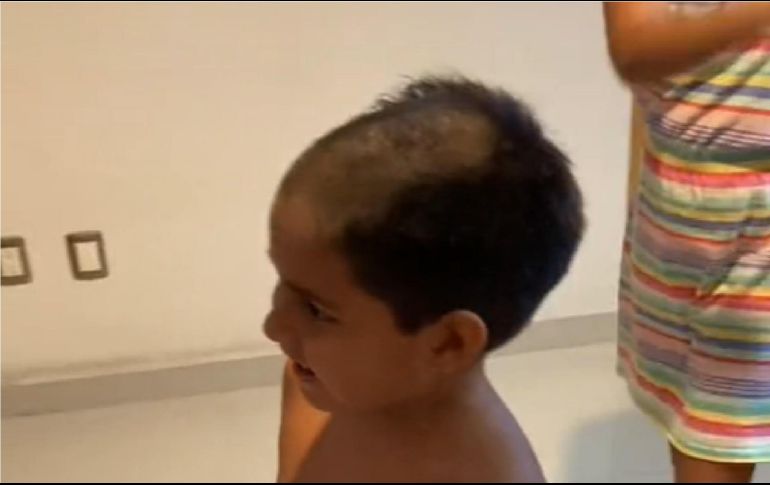 En el video se puede apreciar que el niño llega a una barbería, se sienta en la silla y lleva puesta la bata, además de una gran sonrisa en el rostro. ESPECIAL