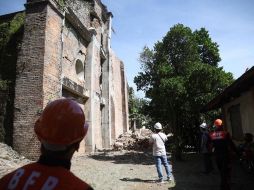 Bomberos inspeccionan los daños en una iglesia en el pueblo de Dingras. EFE/B. Sipin