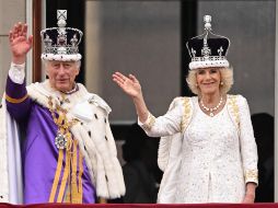 El rey Carlos III y la reina Camila saludan a los asistentes a los alrededores del Palacio de Buckingham tras la coronación. AFP / O. Scarff