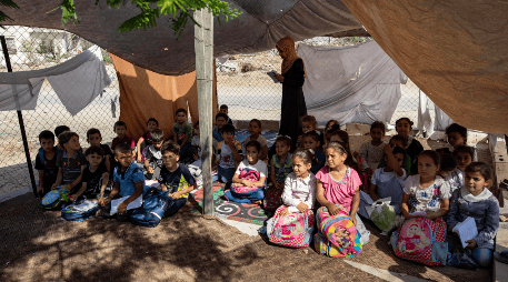 Niños palestinos estudiando en una escuela improvisada, luego de quedarse sin hogar. EFE/H. IMAD