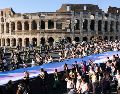 Varias personas pasan por delante del Coliseo durante un desfile del orgullo gay en Roma. Mauro Scrobogna/AP)