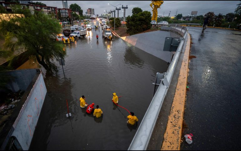 Integrantes de Protección Civil trabajan en un desnivel inundado debido a las fuertes lluvias provocadas por la próxima llegada de la tormenta tropical Alberto, este miércoles en Monterrey.  EFE/M. Sierra.