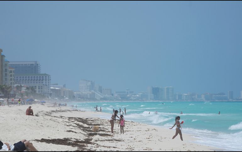 Turistas disfrutan la playa previo a la llegada del huracán 