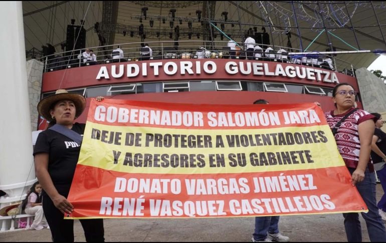 Dos mujeres, presuntas víctimas del Coordinador de Delegados de Paz y del director del Colegio Superior para la Educación Integral Intercultural, protestaron a las afueras del auditorio del Cerro del Fortín durante la fiesta de la Guelaguetza. SUN/RDB.