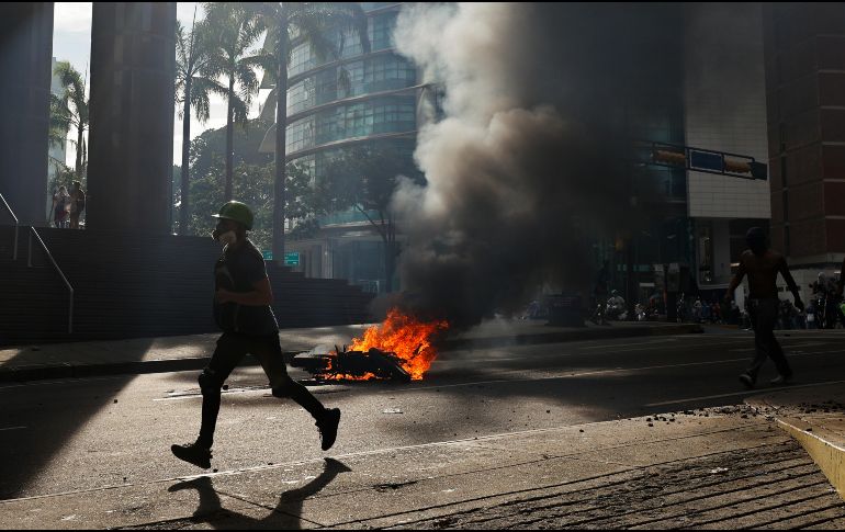 Las imágenes muestran a los manifestantes destruyendo estos símbolos del chavismo mientras gritan 